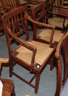 Lot 1219 - An oak and elm rush seated open armchair, together with a similar dining chair (2)