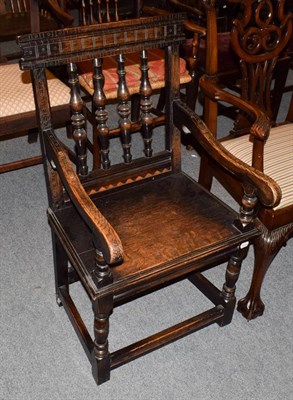 Lot 1232 - A 19th century provincial carved and inlaid oak plank seated open armchair