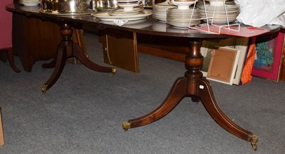 Lot 1252 - A Regency style mahogany twin-pedestal extending dining table, with two additional leaves,...