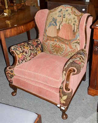 Lot 1255 - A 1920's carved oak framed needlework upholstered wing-chair
