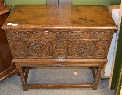 Lot 1264 - A 20th century carved oak chest with a hinged lid above carved panels and turned legs, 79cm by 35cm