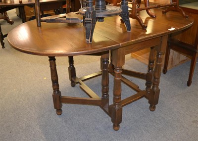 Lot 1281 - A reproduction oak gate leg dining table