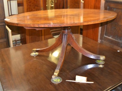 Lot 1329 - A mahogany oval coffee table on four splayed legs, 122cm diameter