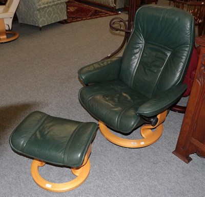 Lot 1366 - An Ekornes green leather reclining chair and footstool