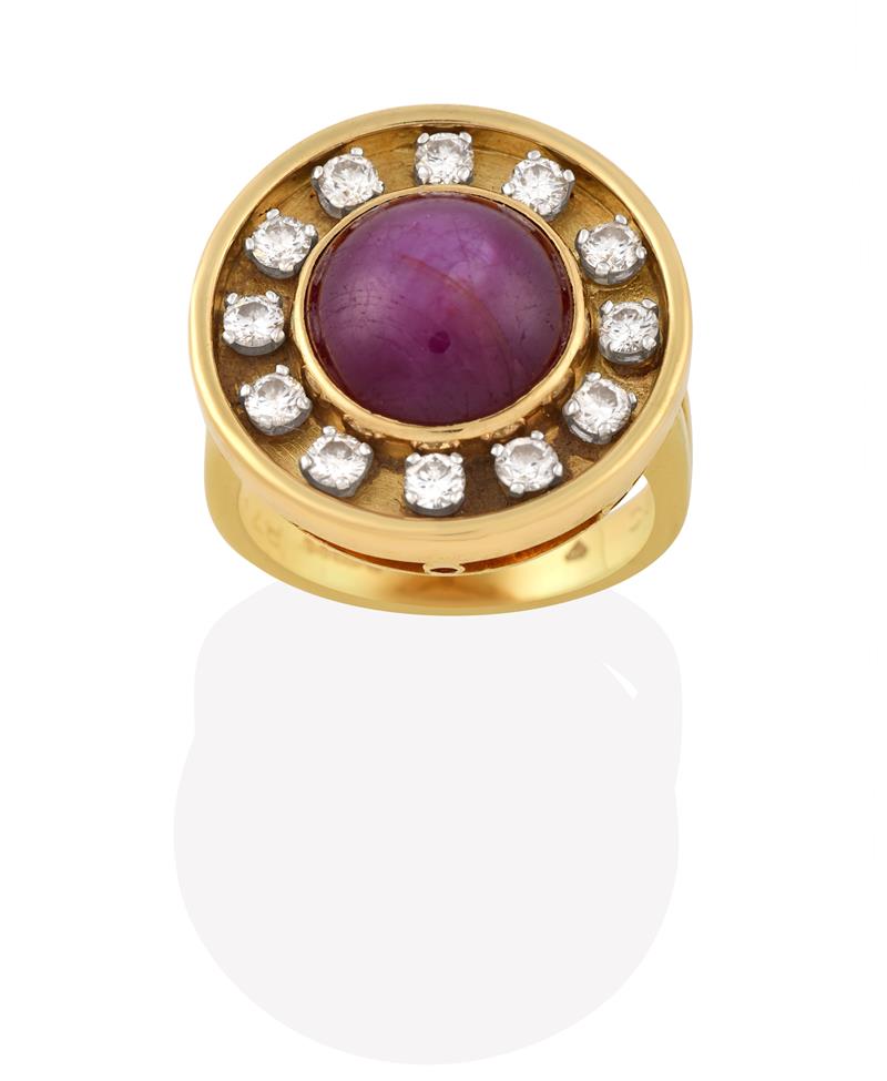 Lot 2019 - An 18 Carat Gold Ruby and Diamond Cluster Ring, the round cabochon ruby in a yellow rubbed over...
