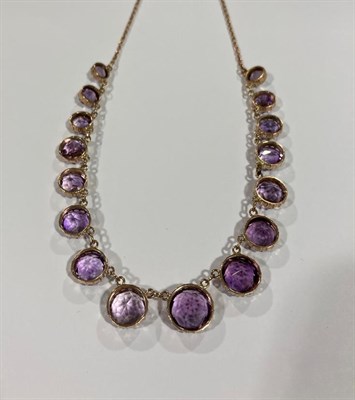 Lot 2022 - An Edwardian Amethyst Necklace, sixteen graduated round cut amethysts in yellow collet settings, to
