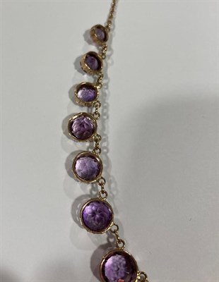 Lot 2022 - An Edwardian Amethyst Necklace, sixteen graduated round cut amethysts in yellow collet settings, to