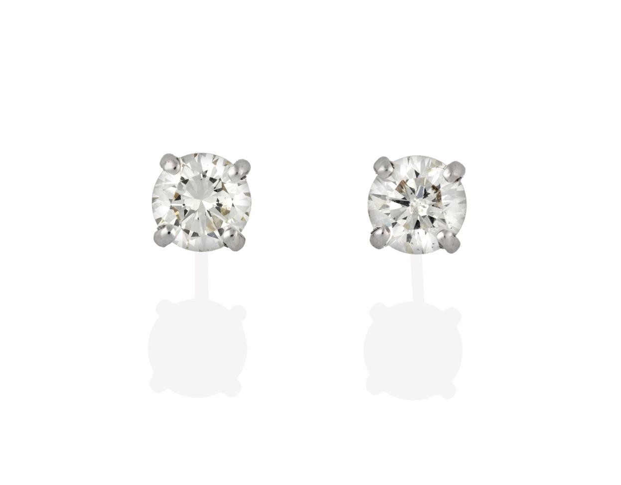Lot 2047 - A Pair of 18 Carat White Gold Diamond Solitaire Earrings, the round brilliant cut diamonds in...