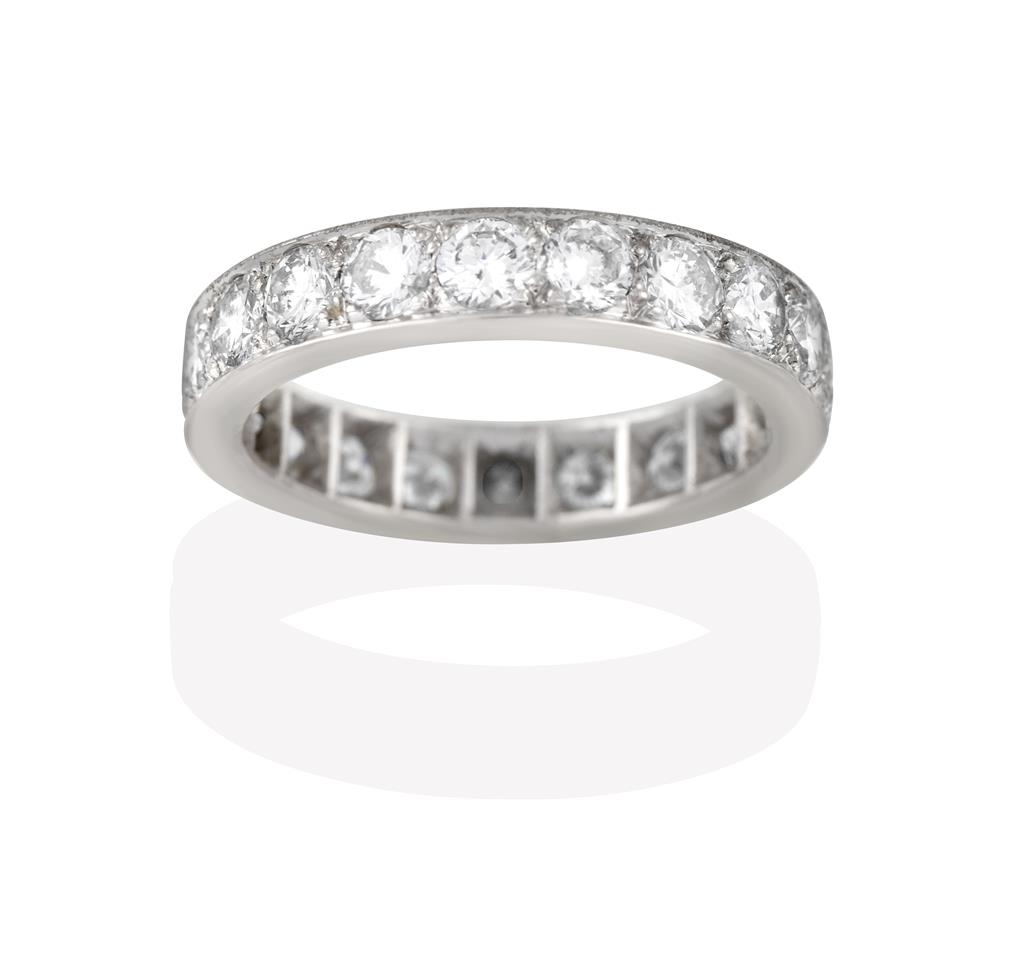 Lot 2049 - A Diamond Eternity Ring, the twenty round brilliant cut diamonds in white claw and channel...