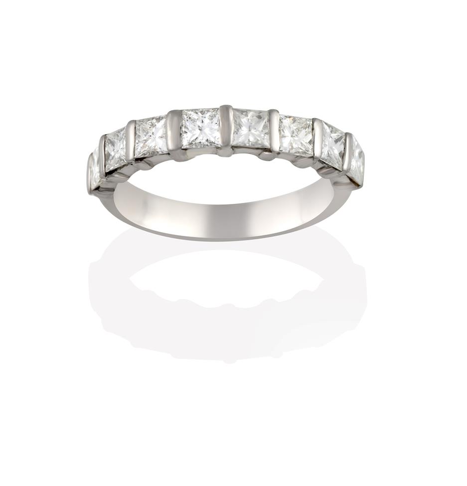 Lot 2050 - A Diamond Half Hoop Eternity Ring, the princess cut diamonds spaced by white bars, to a plain...