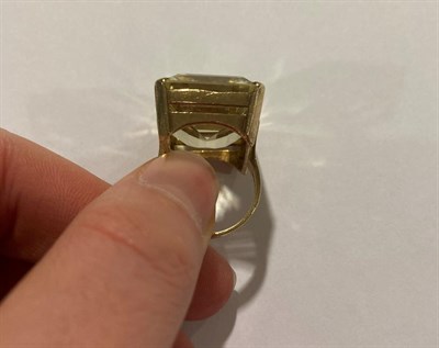 Lot 2069 - A 9 Carat Gold Citrine Ring, the emerald-cut citrine in a yellow four claw setting, to a...