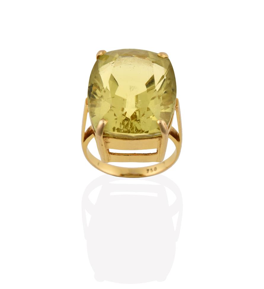 Lot 2070 - A Citrine Ring, the fancy oval cut citrine in a yellow four claw setting, to a tapered shoulder...