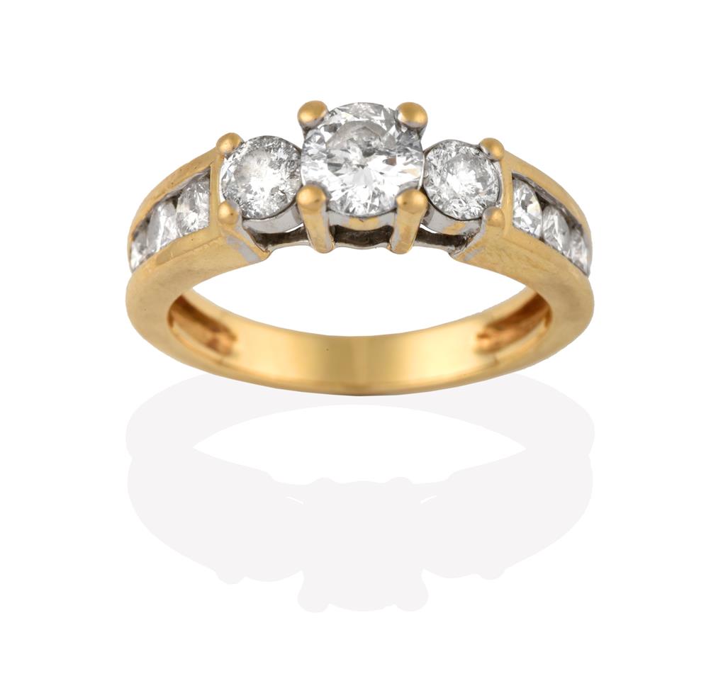 Lot 2073 - A Diamond Three Stone Ring, the graduated round brilliant cut diamonds in yellow claw settings,...