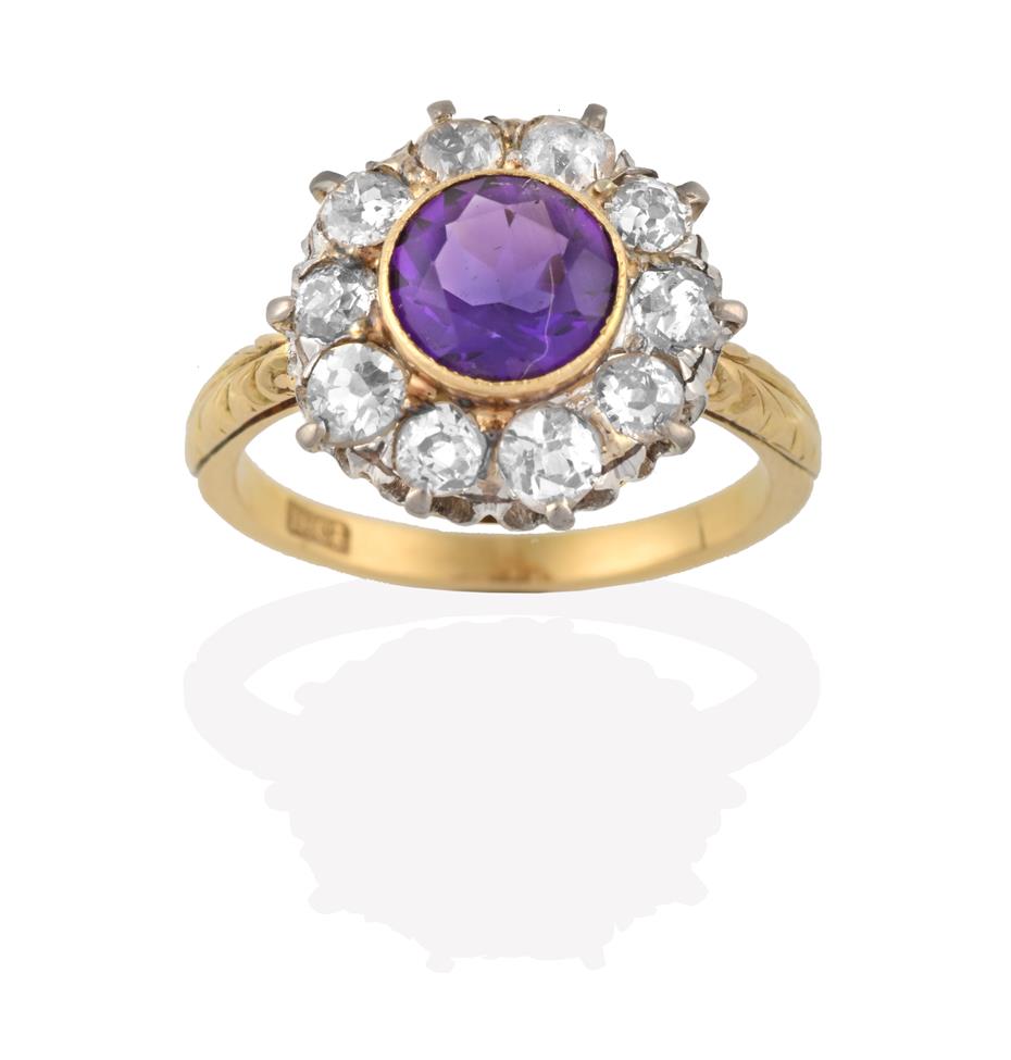 Lot 2076 - An Amethyst and Diamond Cluster Ring, the round cut amethyst in a yellow rubbed over setting,...