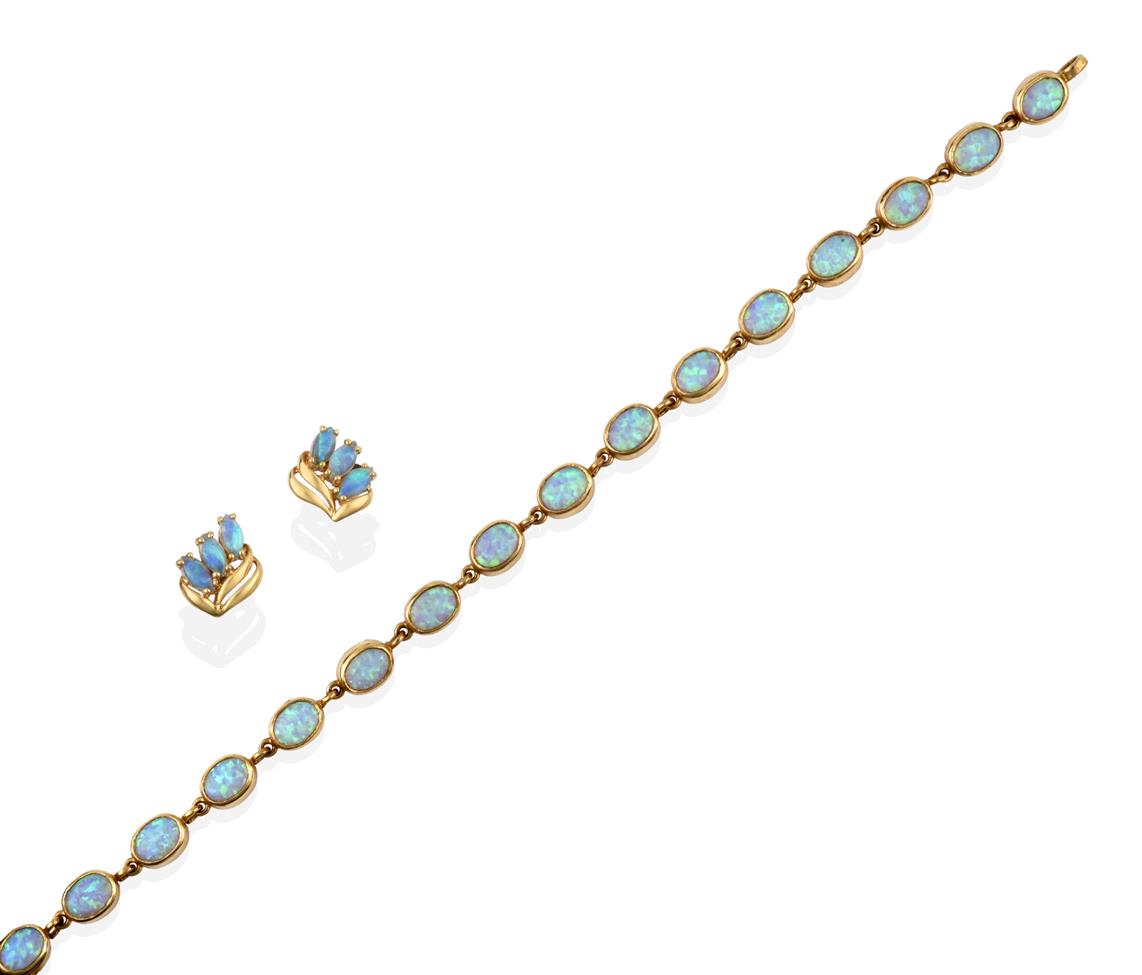 Lot 2082 - An Opal Bracelet, the sixteen chain linked oval cabochon opals in yellow rubbed over settings,...