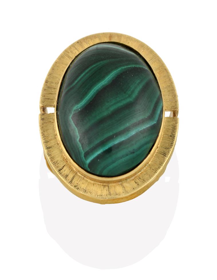 Lot 2084 - A Malachite Ring, the oval cabochon malachite in a yellow rubbed over setting to a further textured