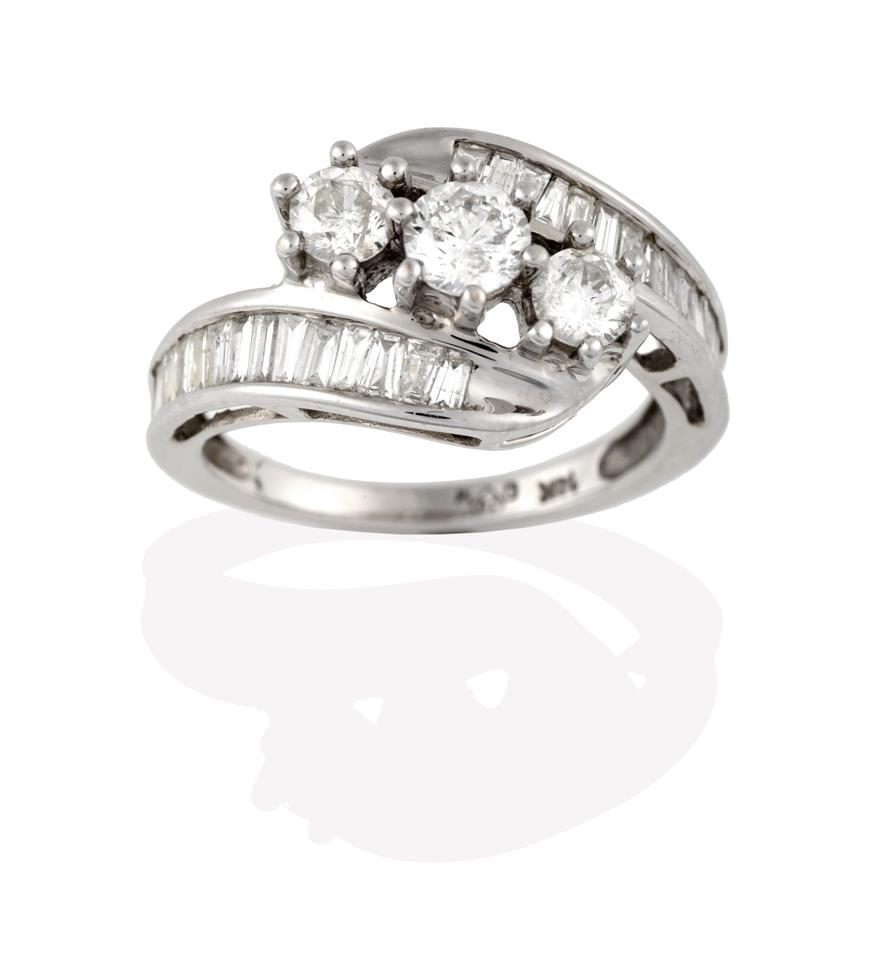 Lot 2089 - A Diamond Three Stone Twist Ring, the graduated round brilliant cut diamonds in white claw...
