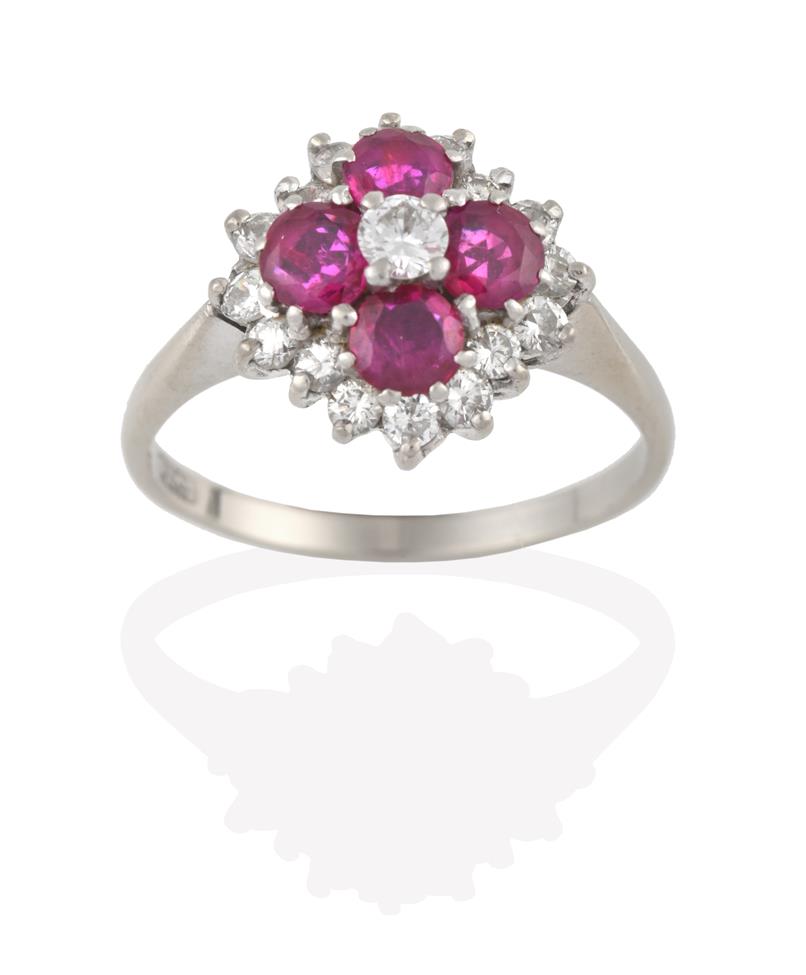 Lot 2094 - A Ruby and Diamond Cluster Ring, the central round brilliant cut diamond within a border of...