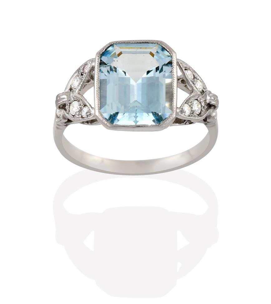 Lot 2106 - An Aquamarine and Diamond Ring, the emerald-cut aquamarine to leaf motif shoulders set...