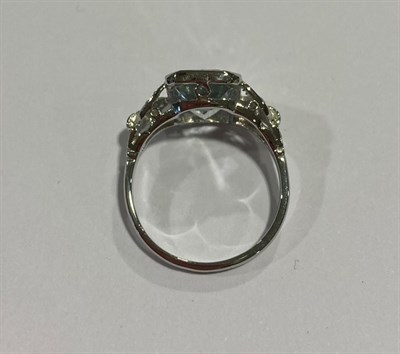 Lot 2106 - An Aquamarine and Diamond Ring, the emerald-cut aquamarine to leaf motif shoulders set...