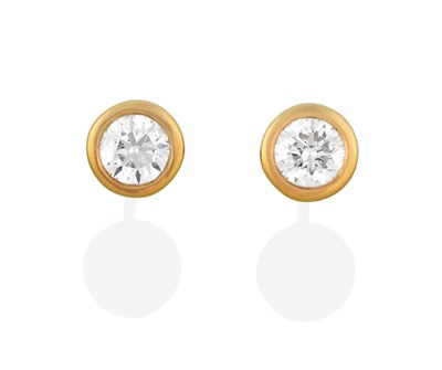 Lot 2123 - A Pair of Diamond Solitaire Earrings, the round brilliant cut diamonds in yellow rubbed over...