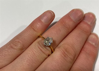 Lot 2144 - A Diamond Solitaire Ring, the oval cut diamond in a white claw setting, to a yellow tapered...
