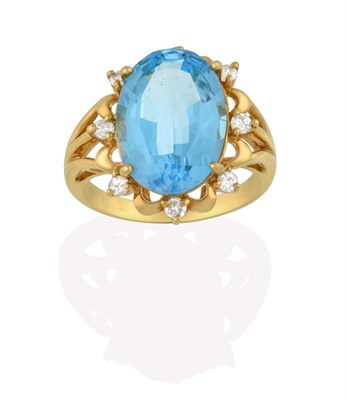 Lot 2151 - An 18 Carat Gold Blue Topaz and Diamond Cluster Ring, the oval cut blue topaz within a spaced...