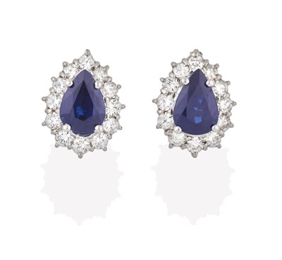 Lot 2186 - A Pair of Sapphire and Diamond Cluster Earrings, the pear cut sapphires within a border of...