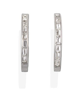 Lot 2192 - A Pair of Diamond Earrings, the white cuff form channel set with baguette cut diamonds, total...