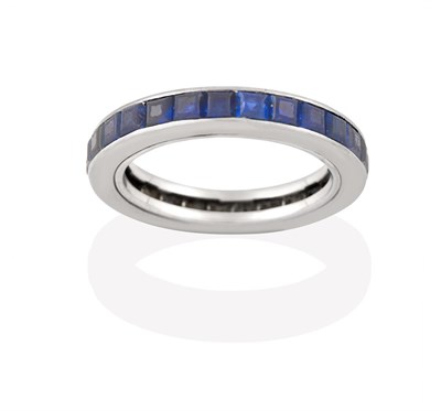 Lot 2195 - A Sapphire Eternity Ring, the calibré cut sapphires in a white channel setting, finger size I...