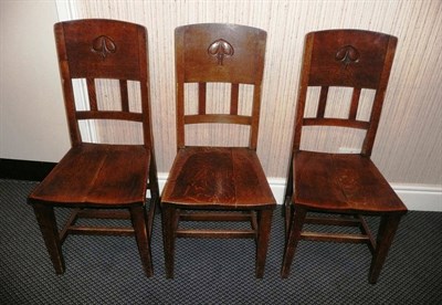 Lot 1724 - A Set of Nine Arts & Crafts Oak Chairs, the back panels with a carved motif above pierced...