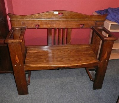 Lot 1725 - An Arts & Crafts Oak Settle, with arched and pierced heart motif rail, above a slatted back,...