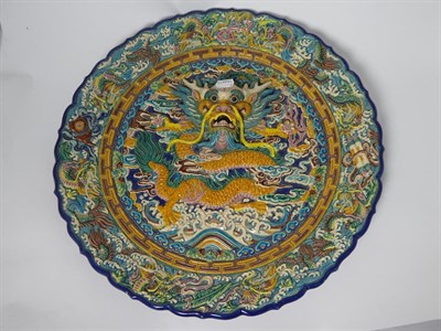 Lot 112 - A Chinese Earthenware Charger, late 19th/20th century, of circular form, moulded in high relief...