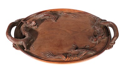 Lot 171 - A Chinese Huanghuali Tray, Qing Dynasty, of oval form, the handles carved as dragons, 70.5cm wide