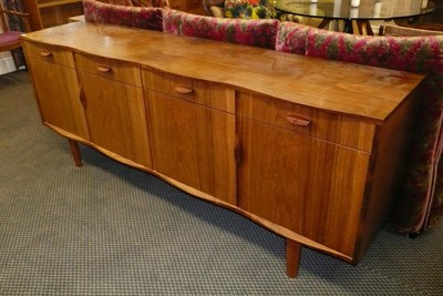 Lot 1751 - A 1960's Rosewood Sideboard, possibly Gordon Russell, with wave front edge above four drawers...