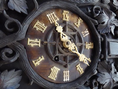 Lot 481 - A Black Forest Cuckoo Striking Wall Clock, circa 1890, elaborately carved decorated front...