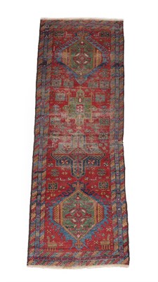 Lot 503 - Heriz Runner North West Iran, circa 1900 The madder field with a column of medallions framed by...