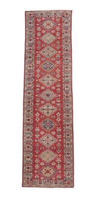 Lot 560 - Afghan Kazak Runner, modern The strawberry field with a column of medallions enclosed by narrow...