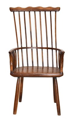 Lot 584 - A Yewwood Stick-Back Armchair, the comb shaped top rail above curved armrests and a solid...