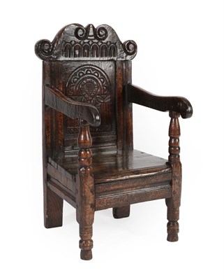 Lot 587 - A Joined Oak Child's Chair, the nulled and scrolled top rail above a flower carved and crescent...