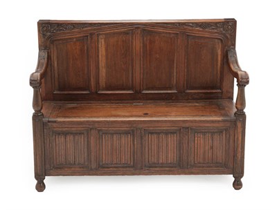 Lot 607 - A Carved Oak Box Settle, circa 1900, the back support with acanthus scrolls and four moulded panels