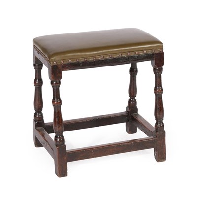 Lot 615 - An Oak Joint Stool, with later close-nailed green leather overstuffed seat, on baluster turned...