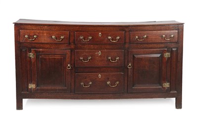 Lot 617 - A George III Oak Enclosed Dresser Base, 3rd quarter 18th century, with four large drawers and...