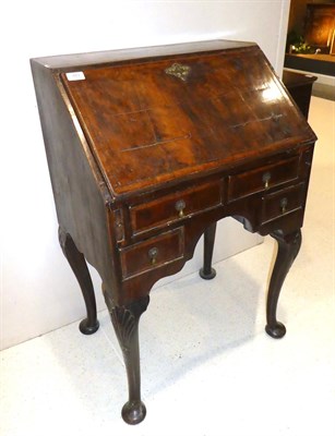 Lot 643 - A Walnut and Crossbanded Small Bureau, in George I style, the fall enclosing a fitted interior...