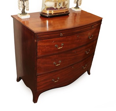 Lot 647 - A George III Mahogany Bowfront Chest of Drawers, late 18th century, with pull-out brushing...