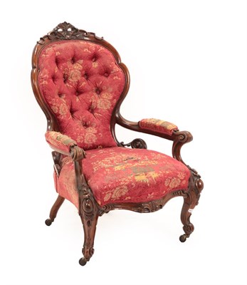 Lot 715 - A Victorian Carved Walnut Open Armchair, circa 1870, covered in buttoned pink floral fabric,...