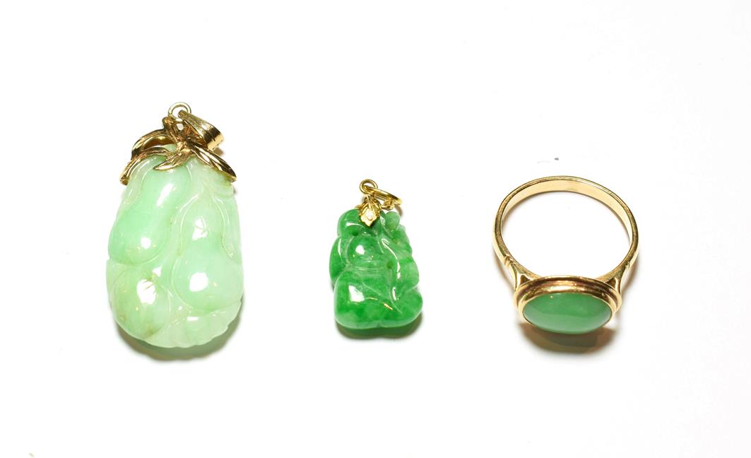 Lot 51 - A jade ring, stamped '14K', finger size Q1/2; and two jade type pendants