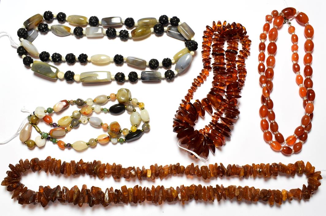 Lot 62 - A chalcedony bead necklace, length 76cm; two irregular shaped amber bead necklaces; and two further