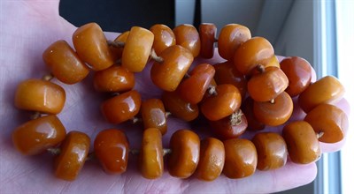 Lot 85 - A 22 carat gold band ring, finger size P; an amber type necklace, length 46.5cm; a cornelian...