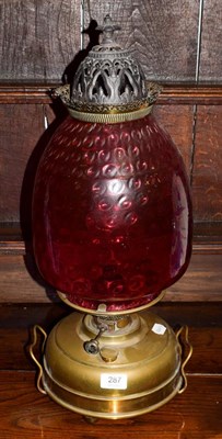 Lot 287 - A cranberry glass brass oil lamp